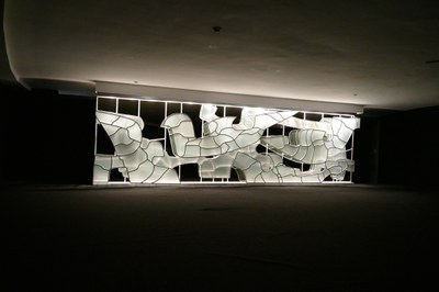 A obra 'Alumbramento', de Marianne Perreti, é composta por uma estrutura de ferro laqueado com espelhos bronze e vidros brancos, criada em 1978. A obra permaneceu encaixotada durante anos no Senado e foi instalada no Salão Branco em 3 de novembro de 2016. 280 x 1000 cm