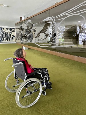 Única mulher na equipe de Oscar Niemeyer na construção da nova capital, a artista Marianne Peretti deixou sua marca pelo Congresso Nacional. No Salão Branco não há como não perceber o painel Alumbramento, doado em 1978 ao Senado Federal. No Salão Verde é exibida a obra Araguaia. As cores e formas de seus vitrais estão também no Salão Nobre, onde pode ser apreciado o vitral Phasifae. No 10º andar do Anexo IV da Câmara dos Deputados, suas mãos foram as responsáveis pelos vitrais da capela. Também na Casa Legislativa, outra obra de destaque: um painel com sobreposição de camadas de vidro, de 1977.     Na foto, Marianne Peretti contempla sua obra "Araguaia", 1977.     Neste painel Marianne Peretti fez uso de uma técnica que parece dar movimento às figuras geométricas colocadas sobre o vidro, lembrando o curso de um rio.     Foto: Walesca Borges/Senado Federal
