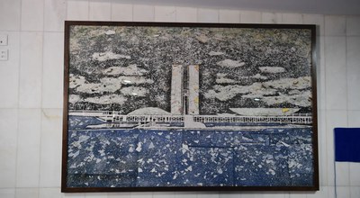 A obra '8 de janeiro de 2023', de Vik Muniz, é uma reprodução fotográfica de um mosaico criado a partir de vidro despedaçado, cartuchos de balas e restos de carpete azul coletados após a invasão ao Senado em 2023, e está localizada no Salão Azul. 280x180 cm